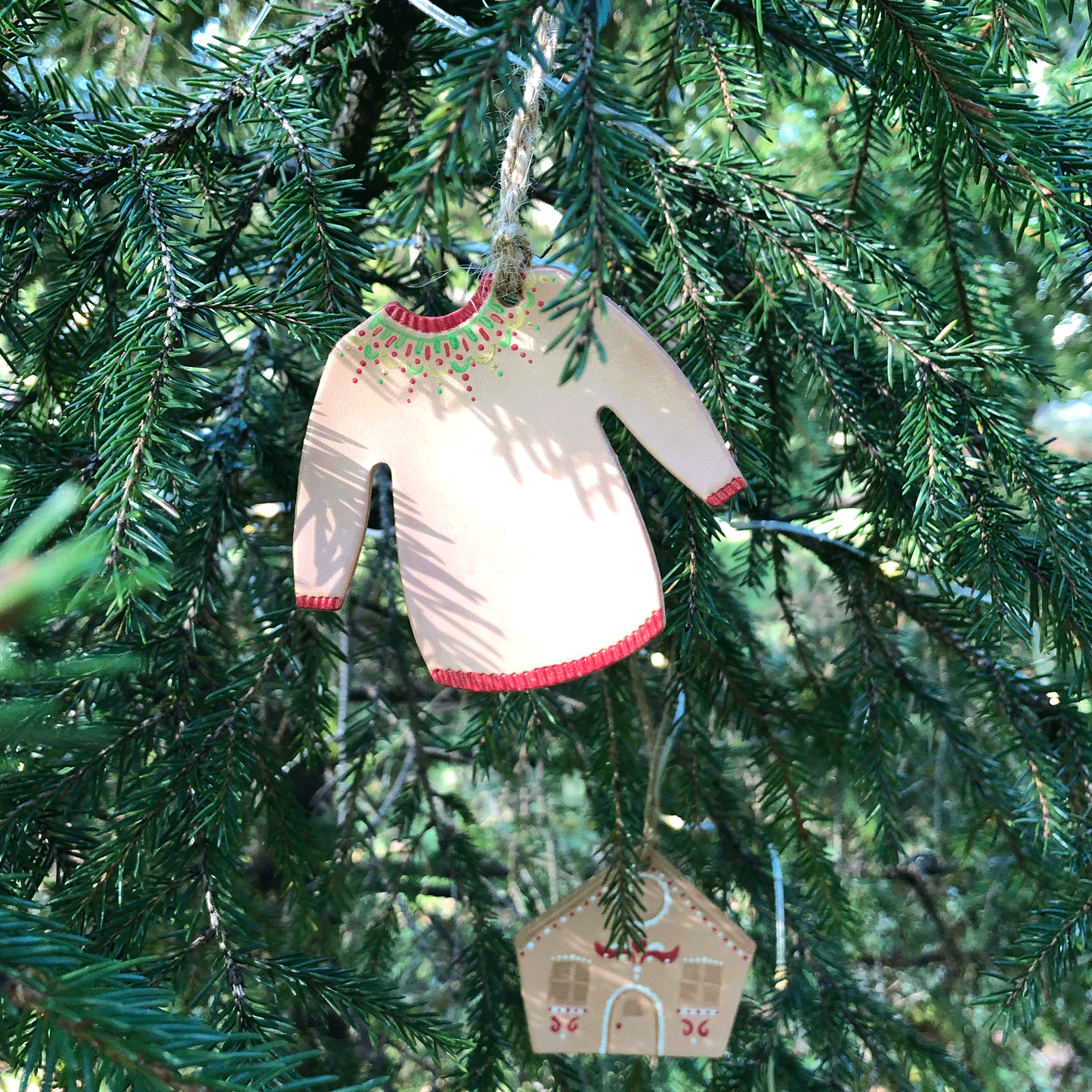 A red painted Christmas jumper hangs in a tree