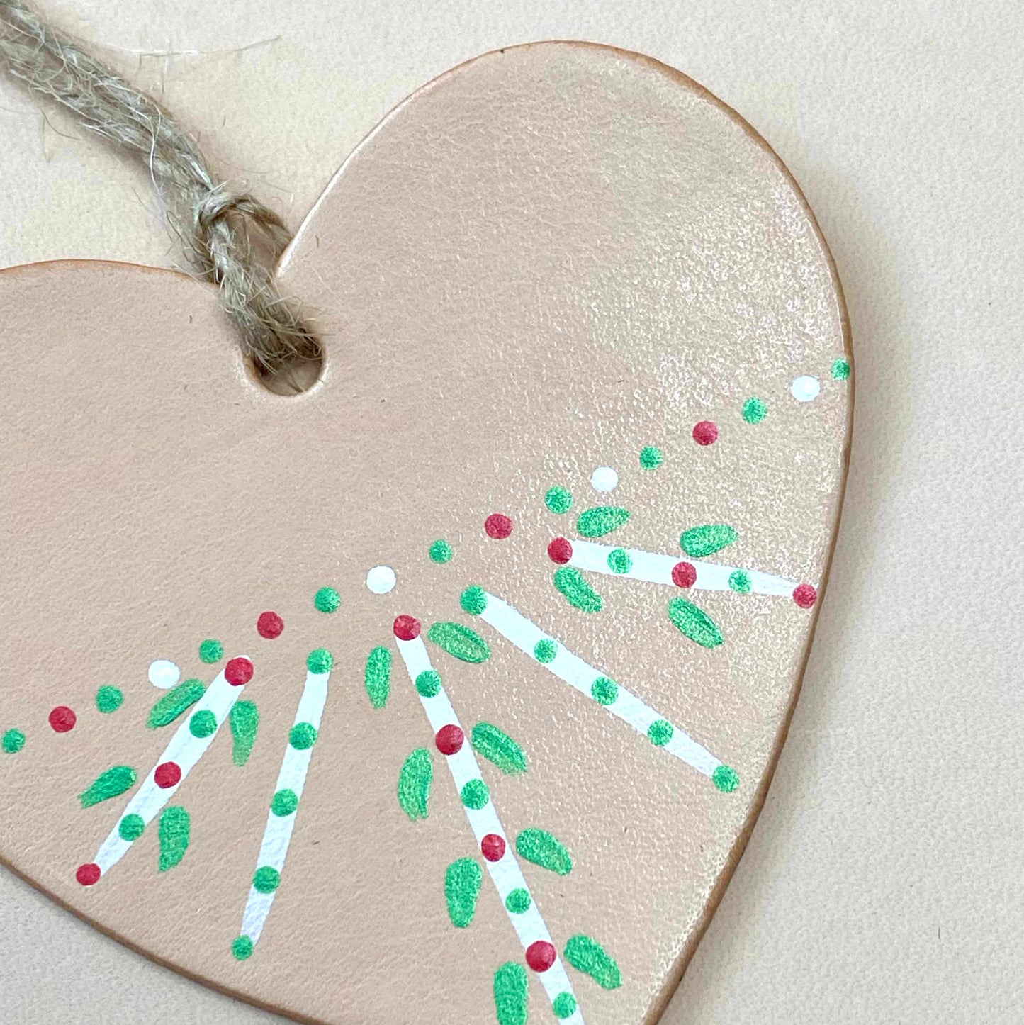 close up of a heart shaped Christmas ornament painted in a folk inspired pattern