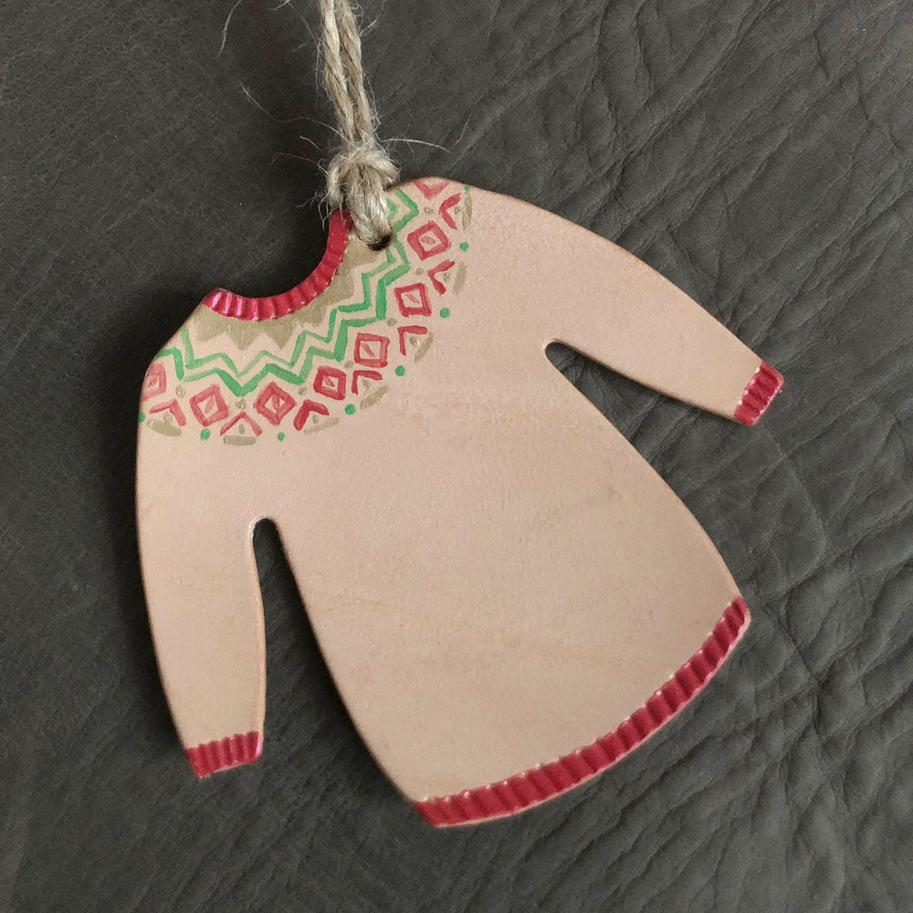 A Christmas jumper tree ornament painted in a red geometric pattern