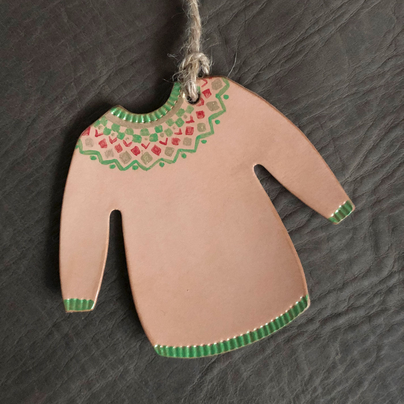 A Christmas jumper decoration painted with a green geometric design