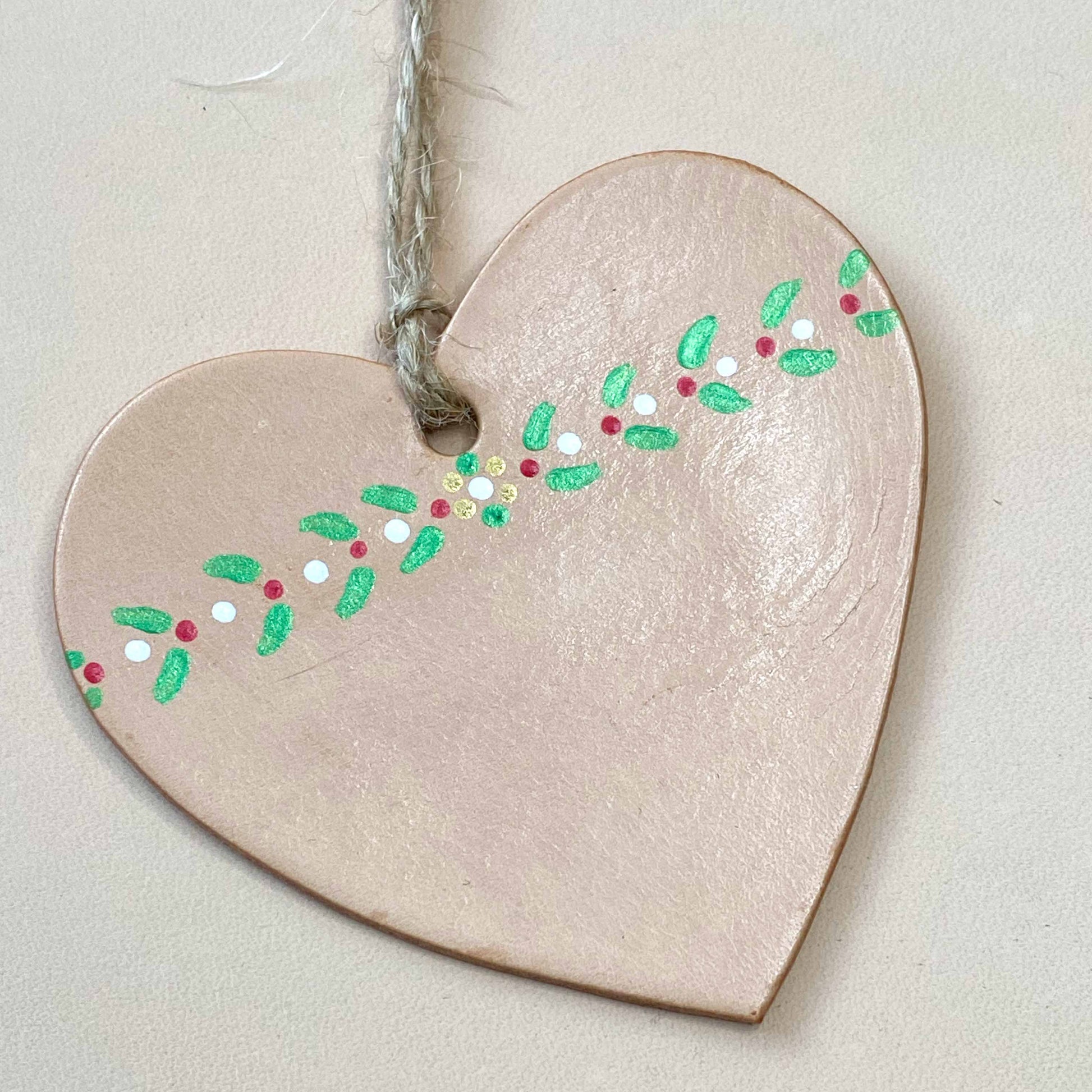 Close up of a painted leather heart shaped Christmas decoration
