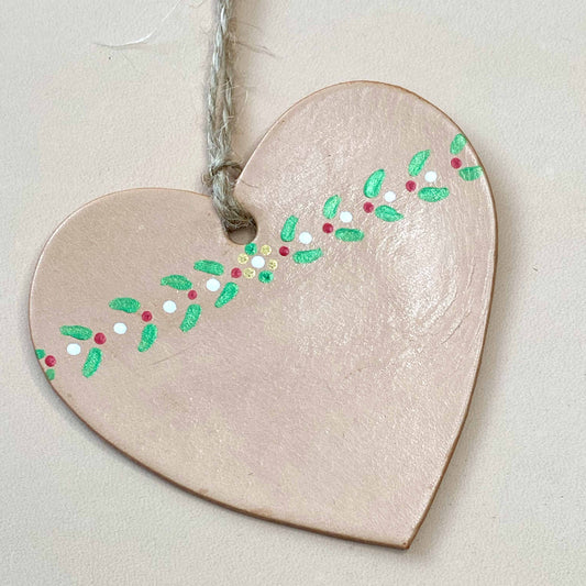 Close up of a painted leather heart shaped Christmas decoration