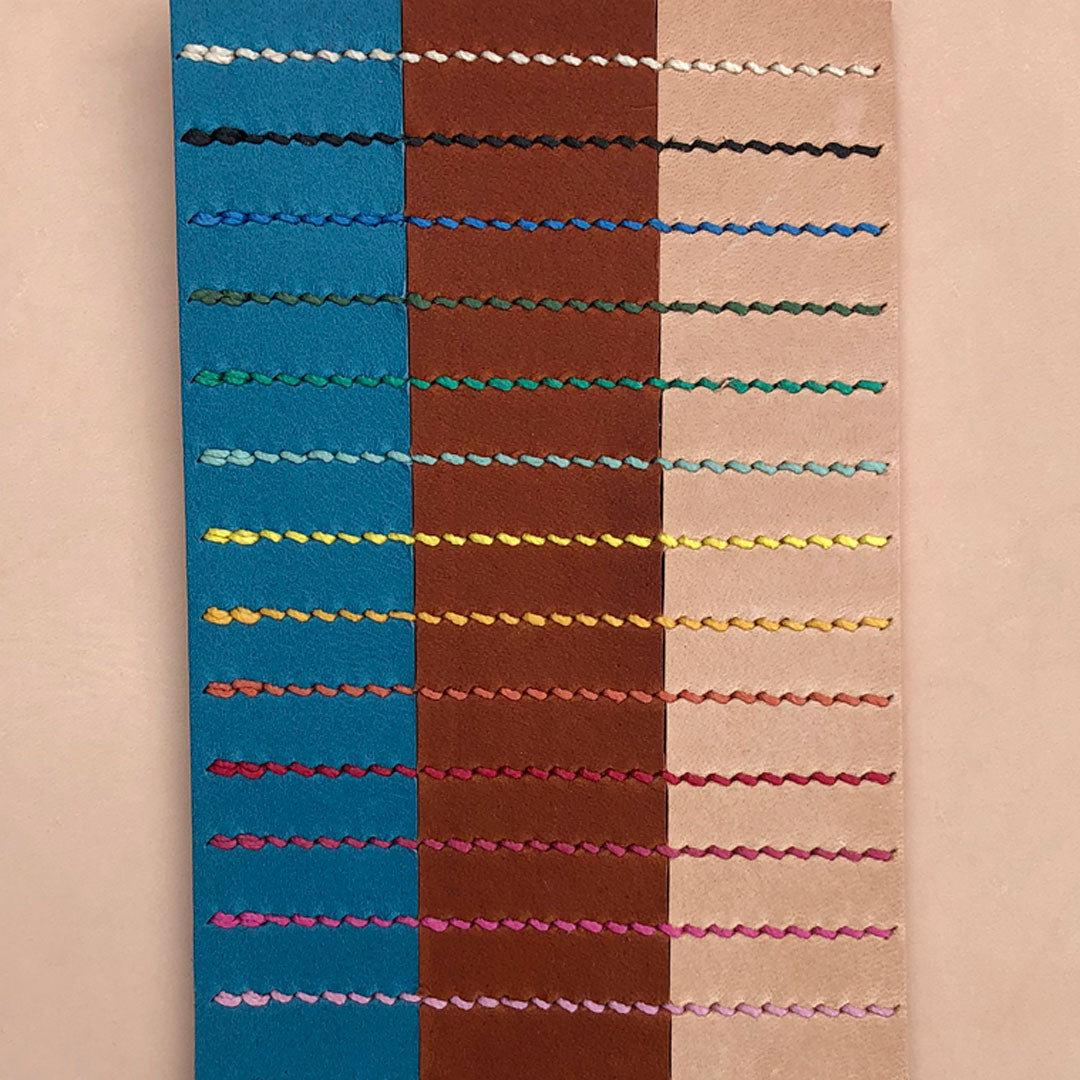 A stitch swatch showing a selection of stitch colours on different leathers. The leather colours from left to right are blue, tan and natural. The thread colours from top to bottom are cream, black, blue, dark green, bright green, aqua, acid yellow, yolk yellow, apricot, red, raspberry, bright pink and barbie pink